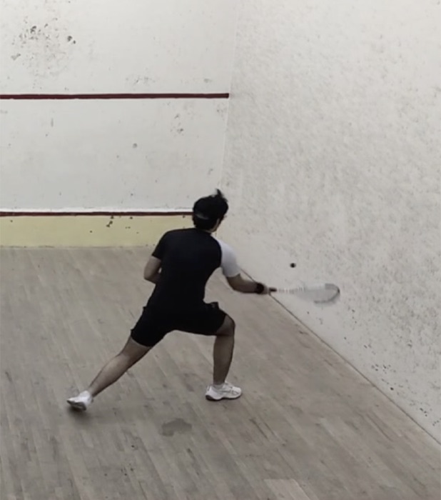 Lunging for a backhand near the wall